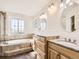 Luxurious bathroom featuring a soaking tub, dual vanities with granite countertops, and natural light at 5843 S Danube St, Aurora, CO 80015