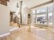 Bright foyer with hardwood floors, staircase, high ceilings, and large windows showing the neighborhood at 5843 S Danube St, Aurora, CO 80015