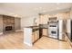 Modern kitchen featuring stainless steel appliances, wood cabinets, and open layout to a brick fireplace living area at 5843 S Danube St, Aurora, CO 80015