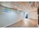 Basement with wood plank ceiling, recessed lights, and wood-look flooring, showing staircase and multiple windows at 764 S Sherman St, Denver, CO 80209