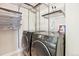 Bright laundry room with modern washer and dryer, and storage shelving at 1076 Mariposa St, Denver, CO 80204