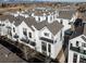 Aerial view of modern townhomes with balconies and landscaped surroundings, close to a city at 1206 S Reed St, Lakewood, CO 80232