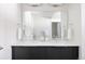 Bathroom features double vanity sinks, a large mirror, and a black vanity with white countertops at 1206 S Reed St, Lakewood, CO 80232