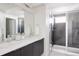 Beautiful bathroom with double vanity sink and enclosed shower with gray tiles at 1206 S Reed St, Lakewood, CO 80232