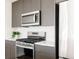 Kitchen featuring stainless steel appliances, gray cabinets, white countertops and tile backsplash at 1206 S Reed St, Lakewood, CO 80232