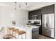 Modern kitchen with stainless steel appliances, a white countertop island, and stylish pendant lighting at 1206 S Reed St, Lakewood, CO 80232