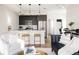 Open-concept living area with a sleek kitchen, bar seating, and comfortable lounge space at 1206 S Reed St, Lakewood, CO 80232