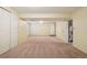 Finished basement space with neutral carpet, white walls, and access to a utility area and a bathroom at 18538 E Whitaker Cir # A, Aurora, CO 80015