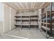 Unfinished basement storage area with open shelving and concrete flooring at 18538 E Whitaker Cir # A, Aurora, CO 80015