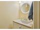 Powder room featuring a white vanity with a gray countertop and a round mirror with a white frame at 18538 E Whitaker Cir # A, Aurora, CO 80015