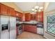 Updated kitchen features stainless steel appliances, cherry cabinets, and tile floors at 18538 E Whitaker Cir # A, Aurora, CO 80015