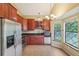 Well-appointed kitchen with cherry cabinets, stainless steel appliances, and natural light at 18538 E Whitaker Cir # A, Aurora, CO 80015