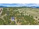 Stunning aerial view of a luxury mountain home surrounded by tall trees, showcasing the natural beauty of the landscape at 24701 Us Hwy 40, Golden, CO 80401