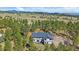 A captivating aerial view of a home nestled amidst lush greenery and rolling hills at 24701 Us Hwy 40, Golden, CO 80401
