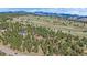 A stunning aerial view of a modern home surrounded by lush greenery and scenic mountain views at 24701 Us Hwy 40, Golden, CO 80401