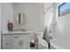 Bright bathroom with a modern vanity, stylish round mirror, and a shower over tub with tiled walls at 24701 Us Hwy 40, Golden, CO 80401