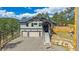 Inviting two-story home featuring a stone porch, a three-car garage and mature landscaping at 24701 Us Hwy 40, Golden, CO 80401