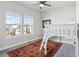 Bedroom with white bed on an orange rug and large windows at 6315 N Emporia St, Denver, CO 80238