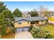 Aerial view showcasing a home with a two-car garage, gray roof, and lush, mature landscaping at 6755 Garrison St, Arvada, CO 80004