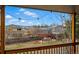 Backyard view from covered porch shows a red pergola and the mountain views beyond at 6755 Garrison St, Arvada, CO 80004