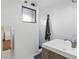 Bathroom features a white sink, mirror, a towel and a shower and a view to the laundry room at 6755 Garrison St, Arvada, CO 80004