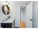 Bathroom featuring marble countertop vanity, round wood mirror, and updated faucet at 6755 Garrison St, Arvada, CO 80004