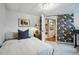 Bedroom with a floral wallpapered accent wall leads to a peek through to another room at 6755 Garrison St, Arvada, CO 80004