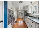 Functional kitchen with white cabinetry, stainless steel appliances, and hardwood floors at 6755 Garrison St, Arvada, CO 80004