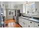 Bright kitchen featuring stainless steel appliances, white cabinets and hardwood floors at 6755 Garrison St, Arvada, CO 80004