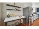 Kitchen with stainless steel refrigerator, butcher block island and floating wooden shelves at 6755 Garrison St, Arvada, CO 80004