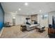 Carpeted living room features a grey sofa, brick fireplace, and stylish mid-century modern decor at 6755 Garrison St, Arvada, CO 80004