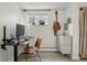 Cozy home office features a window, a brown desk, a brown chair, guitar and storage at 6755 Garrison St, Arvada, CO 80004