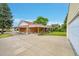 Home exterior with a brick facade, covered patio, and well-maintained landscaping at 2121 W 73Rd Pl, Denver, CO 80221