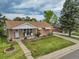 Charming home exterior with a well-kept front yard, flower beds, and covered porch at 2121 W 73Rd Pl, Denver, CO 80221