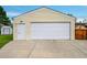 Detached garage with a white door, side door, and a concrete driveway at 2121 W 73Rd Pl, Denver, CO 80221