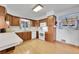 Well-lit kitchen featuring wood cabinets, white appliances, and a window with patterned curtains at 2121 W 73Rd Pl, Denver, CO 80221