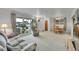 Cozy living room with large windows, a floral sofa, and a dining area with a wooden table at 2121 W 73Rd Pl, Denver, CO 80221