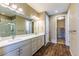 Bathroom featuring a double vanity, framed mirror, glass shower, and a walk-in closet at 22662 E Narrowleaf Cir, Aurora, CO 80016