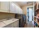 Functional laundry room with ample storage cabinets, sink, and modern washer and dryer at 22662 E Narrowleaf Cir, Aurora, CO 80016