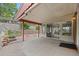 View of the covered back patio with adjacent garden area with brick accents leading to the sunroom at 8205 Pennsylvania St, Denver, CO 80229