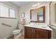 Bright bathroom featuring wood cabinets, a large mirror, and tiled floors at 8205 Pennsylvania St, Denver, CO 80229