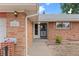 Brick home entrance featuring a walkway leading to the door and the house number is displayed at 8205 Pennsylvania St, Denver, CO 80229