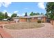 Charming single-story brick home with manicured lawn, circular driveway, and attached garage at 8205 Pennsylvania St, Denver, CO 80229