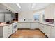 Bright kitchen features light-colored cabinets, updated appliances, and wood floors at 8205 Pennsylvania St, Denver, CO 80229
