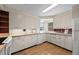 Bright kitchen features light-colored cabinets, updated appliances, and wood floors at 8205 Pennsylvania St, Denver, CO 80229