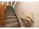 Carpeted stairway with wood handrail and a motorized chair lift system installed for ease of access at 8205 Pennsylvania St, Denver, CO 80229