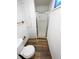 Bathroom featuring a shower with glass doors, toilet and wooden floors at 13477 E Center Ave, Aurora, CO 80012
