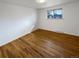 Empty bedroom with hardwood floors and bright window at 13477 E Center Ave, Aurora, CO 80012