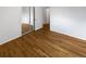 Bedroom featuring hardwood floors, double sliding door closet, and doorway to a hallway at 13477 E Center Ave, Aurora, CO 80012
