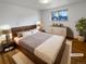 Staged bedroom with hardwood floors, large window, and elegant furnishings at 13477 E Center Ave, Aurora, CO 80012